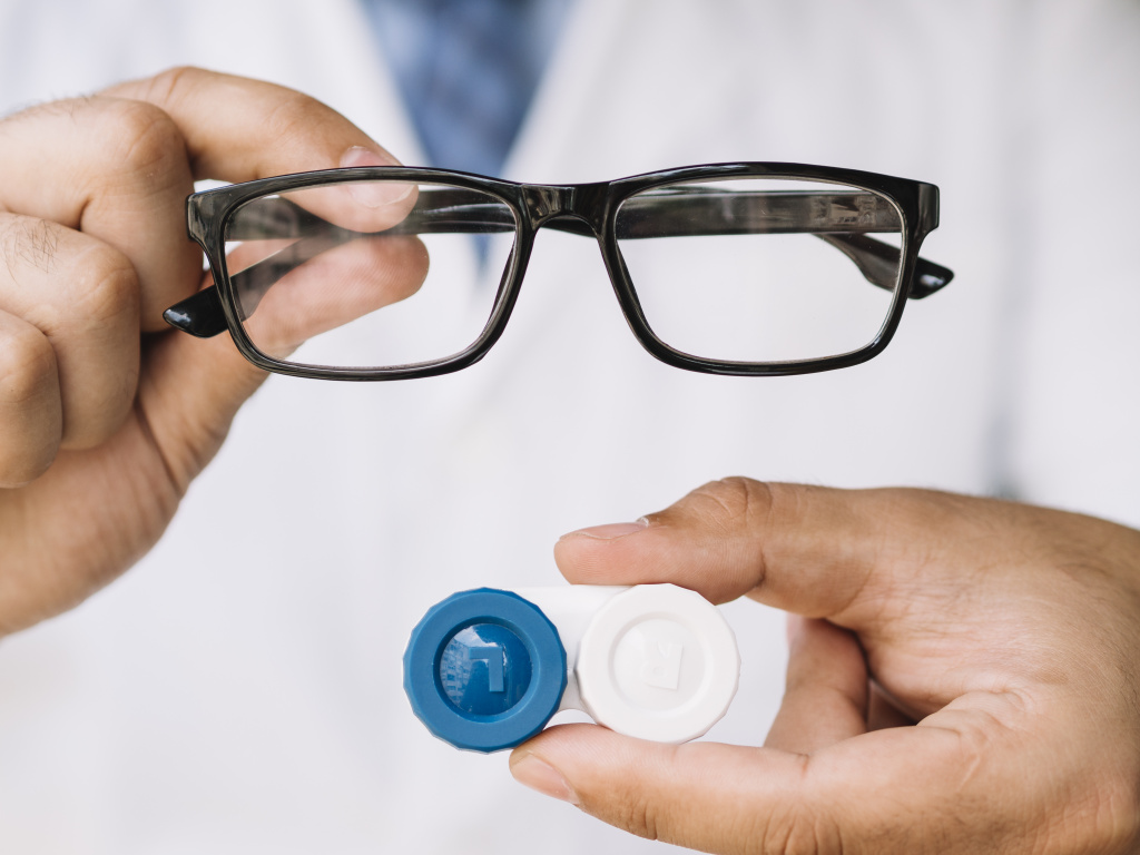 male-doctor-showing-pair-of-black-glasses-and-contact-lens.jpg